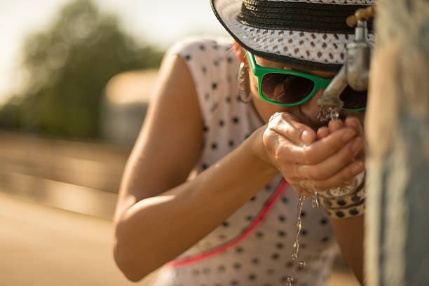 Young caucasian woman drinking water on the train station.