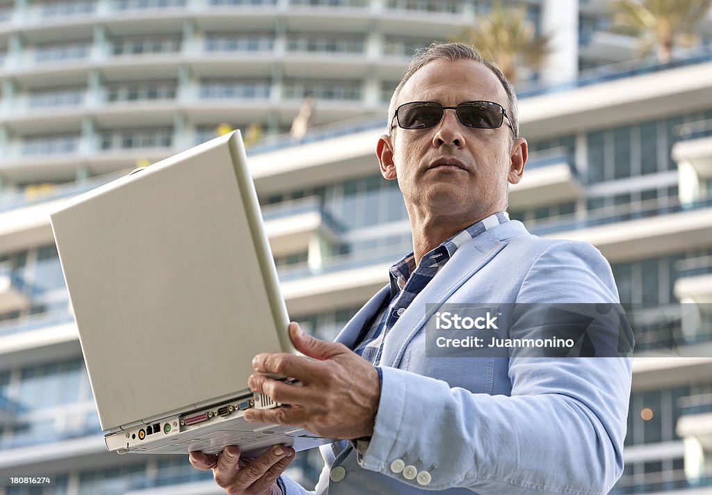 Business man fifty something businessman posing with his laptop looking up in the city 50-54 Years Stock Photo