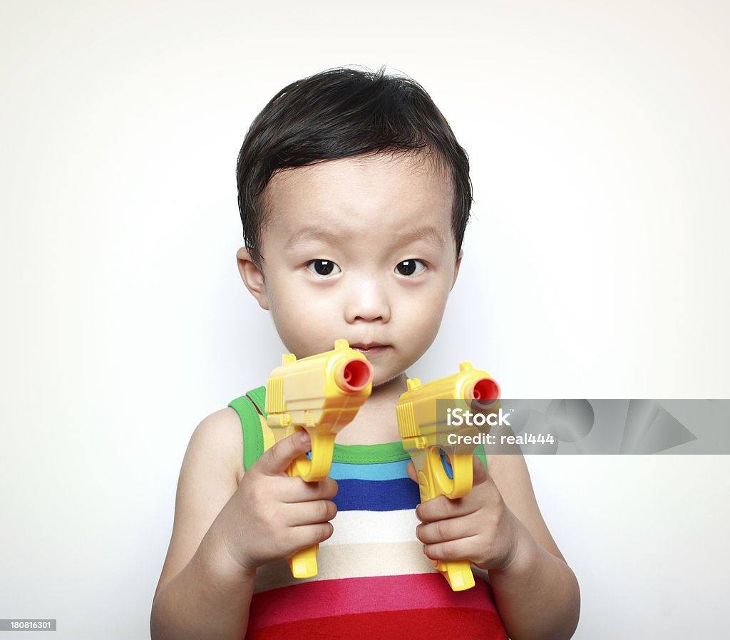 Linda Ásia crianças brincando com Arma de Brinquedo - Foto de stock de 12-17 meses royalty-free