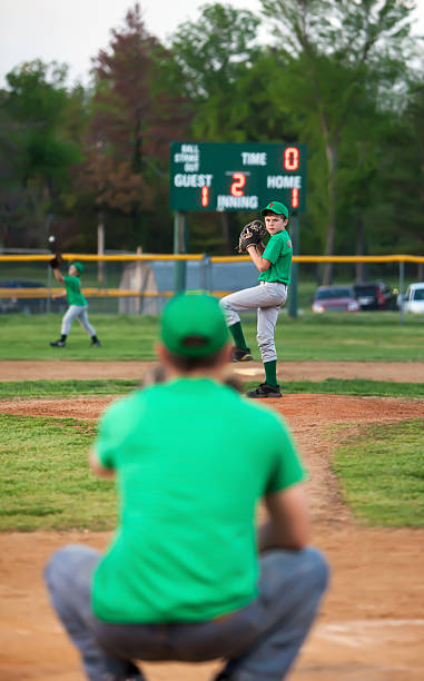 coach dad catches for pitcher son "a Father and head coach of a little leauge baseball team squats behind home plate between innings warming up the pitcher, who is also his son." tie game stock pictures, royalty-free photos & images