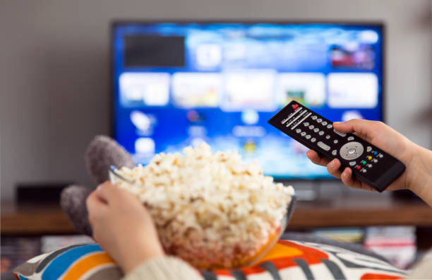 istock young woman watching tv 180816539