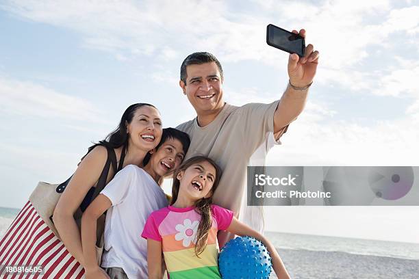 Uomo Con La Sua Famiglia Prendendo Autoritratto In Spiaggia - Fotografie stock e altre immagini di Famiglia