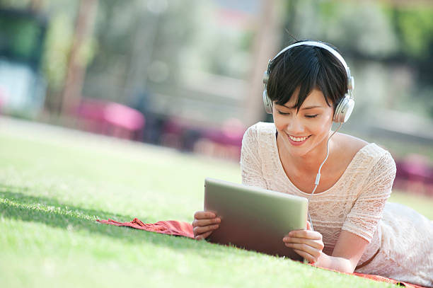 Woman with digital tablet in the park stock photo