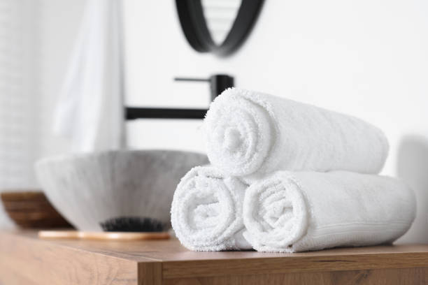 istock Rolled bath towels on wooden table in bathroom. Space for text 1808170950