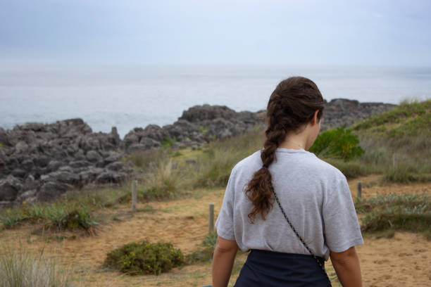 istock Young woman waling on the coast 1808175250