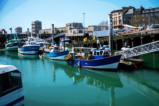 Small and larger  amazing  fishing boats in special harbor for them in Le havre. Noon day in May