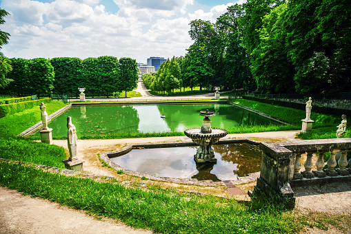 Amazing view in National Estate of Saint-Cloud (Saint-Cloud park)  with pond  and old statues and topiary trees in direction to Seine river (not visible- about 200 meters)