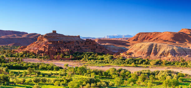 Panoramic view of Aït Benhaddou and High Atlas mouintain range Aït Benhaddou is a fortified city along old caravan route between the Sahara Desert and Marrakech. The city is also on a UNESCO World Heritage List and has featured in many films like Lawrence of Arabia, Gladiator, Jewel of the Nile, Kingdom of Heaven, Kundun and Alexander.http://bhphoto.pl/IS/morocco_380.jpg ait benhaddou stock pictures, royalty-free photos & images