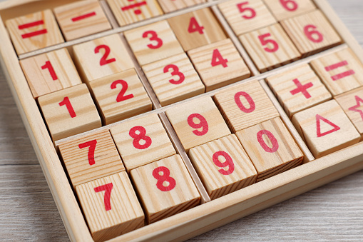 Math game with numbers on white wooden table, closeup