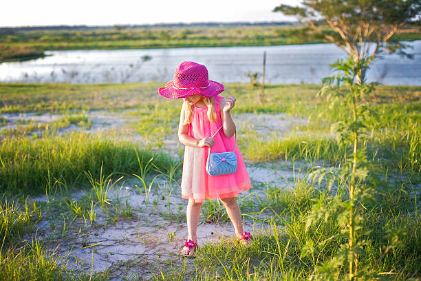 Cтоковое фото Изысканный маленькая девочка в розовом платье в поле