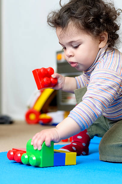 istock Baby Girl Playing With Plastic Building Blocks 180818294