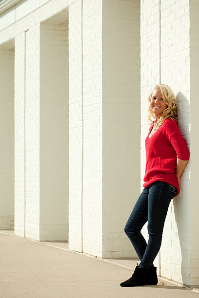 istock Pretty Young Blonde Girl Leaning against White Wall 180819406