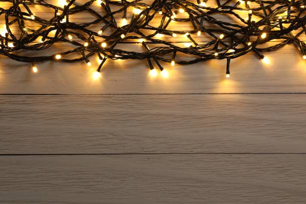istock Glowing festive lights on wooden background, top view. Space for text 1808194694