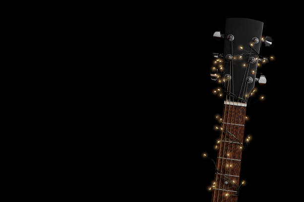 istock Guitar with fairy lights on black background, space for text 1808195214