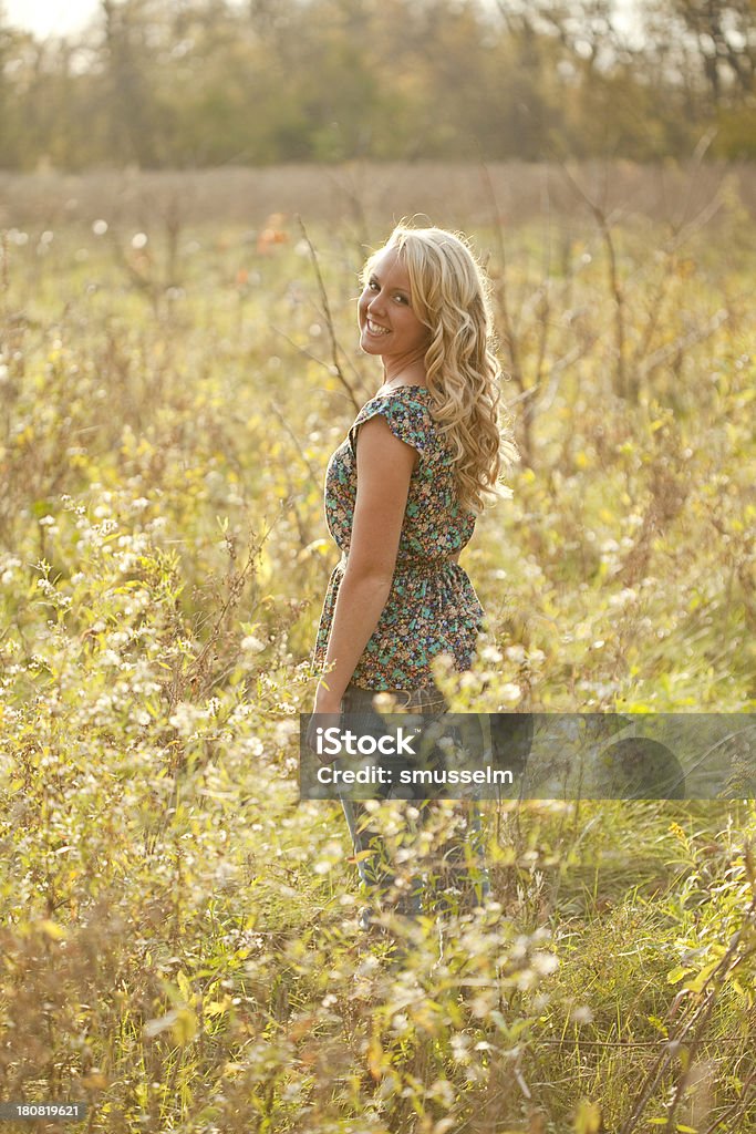 Bella giovane ragazza bionda In piedi In un campo - Foto stock royalty-free di 18-19 anni