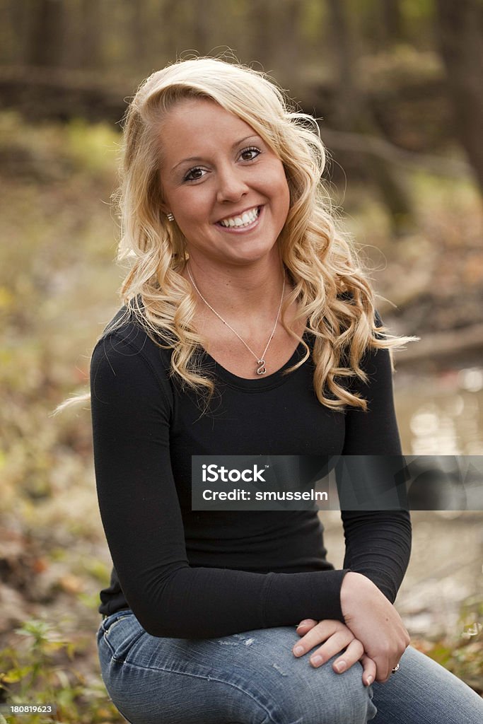 Hermosa chica rubia joven sentado en el bosque - Foto de stock de 18-19 años libre de derechos