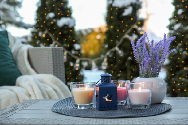 istock Beautiful burning candles, lantern and potted flowers on table outdoors. Cozy winter 1808196301