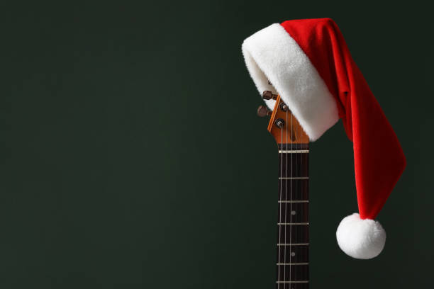 istock Guitar with Santa hat on green background, space for text 1808197387