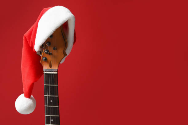 istock Guitar with Santa hat on red background, space for text 1808197395