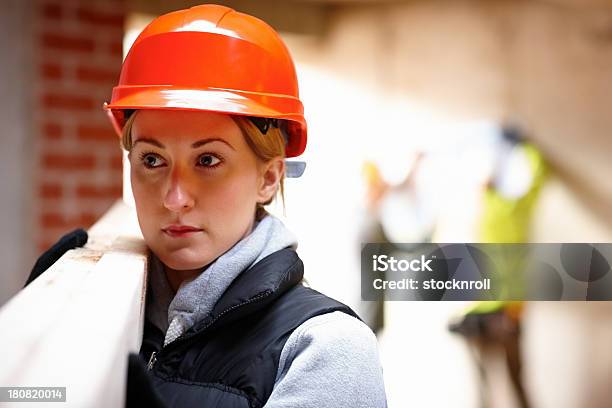 Foto de Jovem Trabalhadora Carregando Vigas De Madeira e mais fotos de stock de Mulheres - Mulheres, 20-24 Anos, Adulto