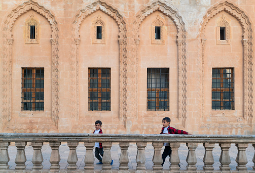 Brothers running on the inner terrace of the stone mansions of the historical city of Mardin. The building, which is one of the most beautiful examples of Mardin civil architecture, attracts attention with its rich and magnificent stone workmanship. The fine stone workmanship on the door and window jambs, interior niches and mihrabiye is remarkable. Taken in daylight with a full frame camera.