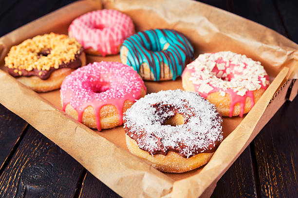 Fresh homemade donuts with various toppings A box with fresh homemade donuts with icing. donut stock pictures, royalty-free photos & images