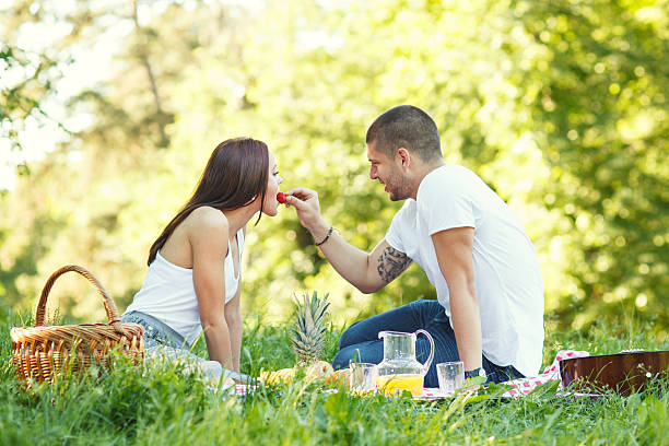 istock Young man feeds his girlfriend with strawberries 180820419