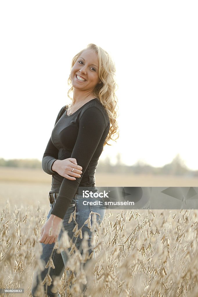 Pretty Young Blonde Girl Standing In A Field - Foto de stock de 18-19 años libre de derechos