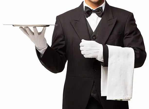 Midsection of butler holding an empty serving tray and a white napkin . Horizontal shot. Isolated on white.