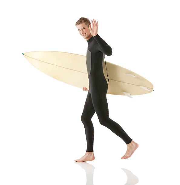 istock Surfer holding surfboard and waving hands 180821194