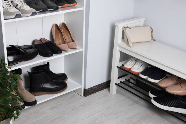 istock Shelving unit and shoe storage bench near white wall in hallway. Interior design 1808215801