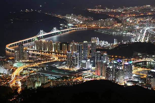 "Night view at Busan cityscape and The Gwangan Bridge (Diamond Bridge) in Busan, South Korea.  Busan Metropolitan City is South Korea's second largest metropolis after Seoul, with a population of approximately 3.6 million. The Metropolitan area (includes adjacent cities of Gimhae and Yangsan) population is 4,573,533 as of December 2012.  It has Korea's largest beach and Korea's longest river. It is the largest port city in South Korea and the world's fifth busiest seaports by cargo tonnage."