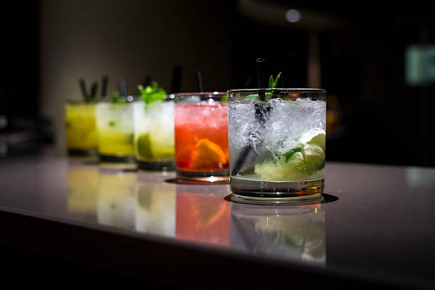 Glass cups filled with different flavored mojitos Several flavored mojitos on a bar. cocktail stock pictures, royalty-free photos & images