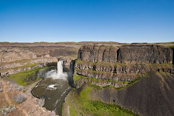 Palouse Falls At the end of the last ice age, the great Missoula Flood swept across eastern Washington leaving the unique scablands we see today. Palouse Falls, 198 feet high, remains as one of the magnificent remnants of the flood. As of February 12, 2014, Palouse Falls was named as Washington State's official waterfall. The powerful waterfall is on the Palouse River, a few miles upstream from its confluence with the Snake River. This view was captured from Palouse Falls State Park, Washington State, USA. jeff goulden palouse stock pictures, royalty-free photos & images