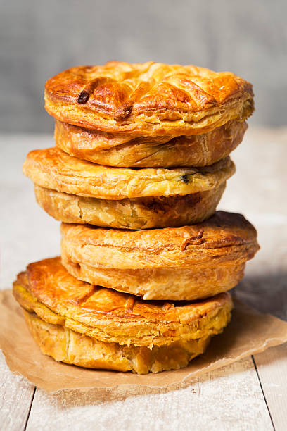 Stack of homemade meat pies on a rustic table
