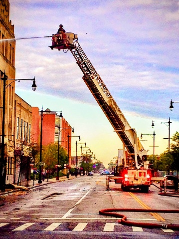 The hook and ladder truck from the fire department arrives to dose this early morning fire on a vacant building