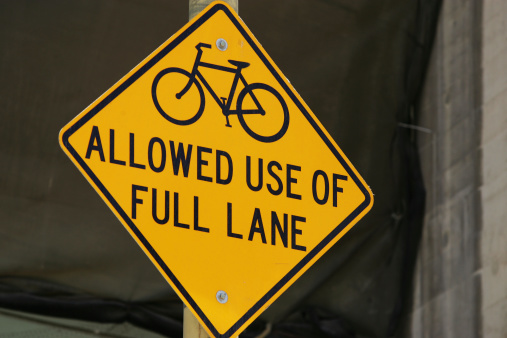 A bike lane sign in San Francisco that informs motorists and cyclists that bikes are allowed to use the full lane.