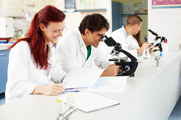 gli scienziati che lavorano in laboratorio - biotechnology student laboratory nurse foto e immagini stock