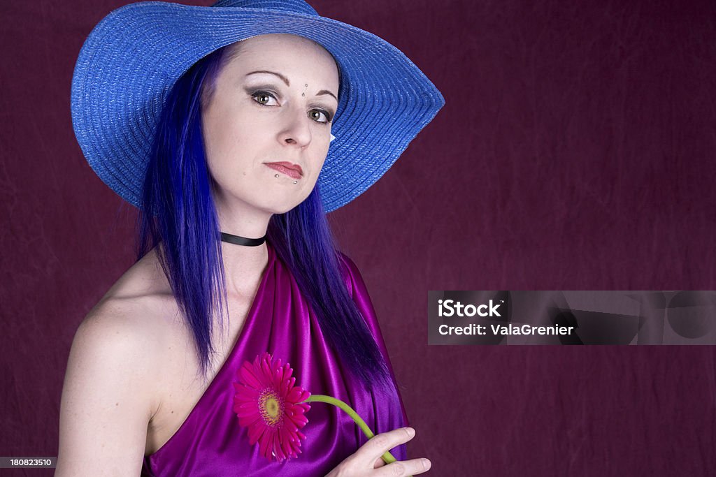 Серьезные женщина в синей шляпе с цветком на темно-розового цвета. - Стоковые фото 30-34 года роялти-фри