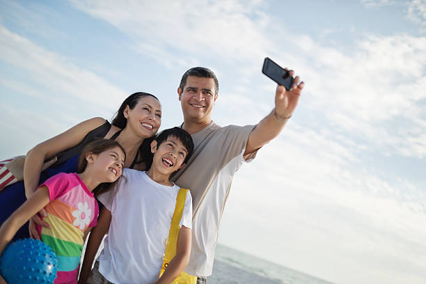 istock Father With Family Taking Self Portrait Through Mobile Phone 180823638