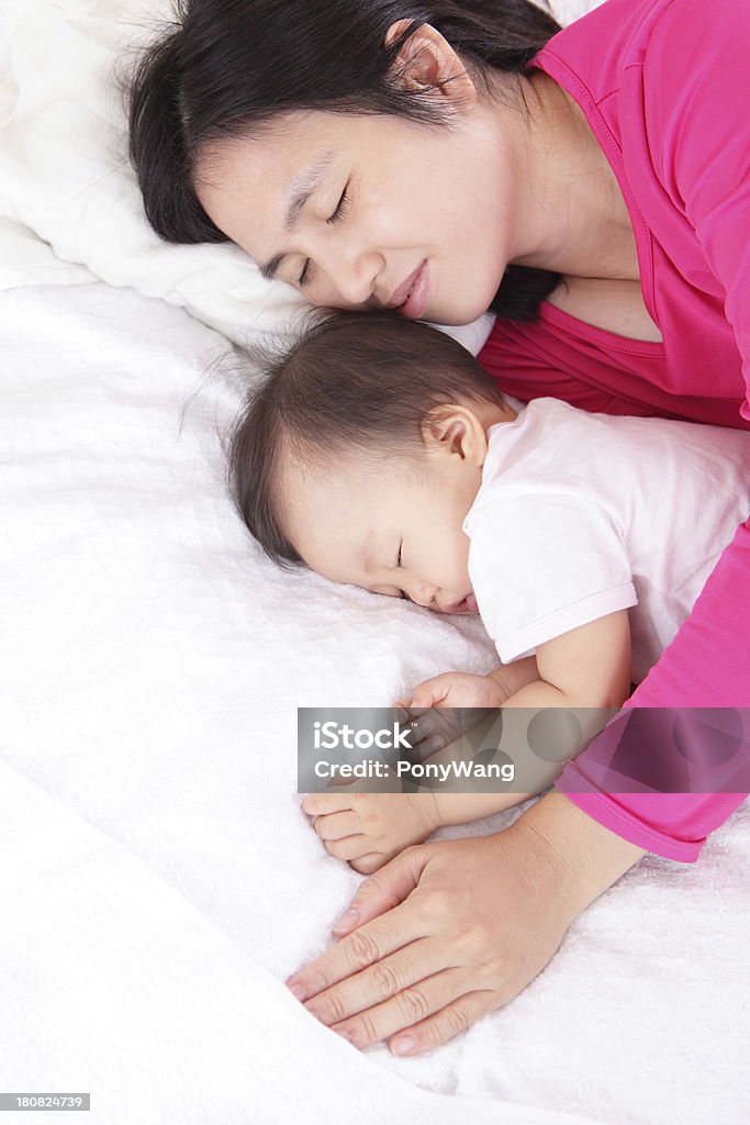 Giovane madre bambino di look suo letto - Foto stock royalty-free di Abbracciare una persona