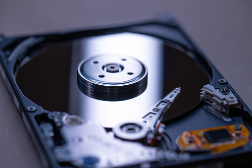 Mechanics inside a hard disk drive with platter and read write head.