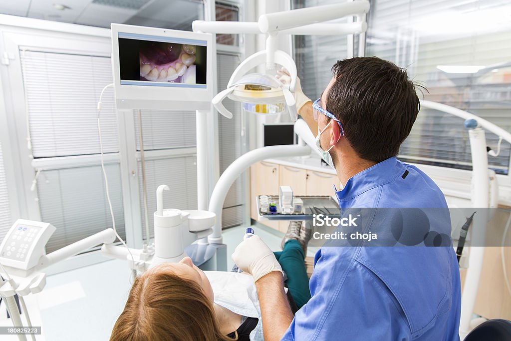Dentiste au travail, à l'aide de caméra intraoral, regarder les photos sur écran - Photo de Appareil photo libre de droits