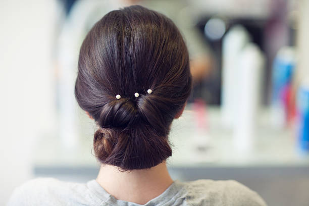 Haircut Close up of a beautiful bun with white pearls. hair bun stock pictures, royalty-free photos & images