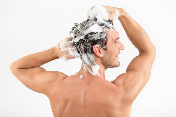 Man washing hair with shampoo Rear view of a young man washing hair with shampoo. washing hair stock pictures, royalty-free photos & images
