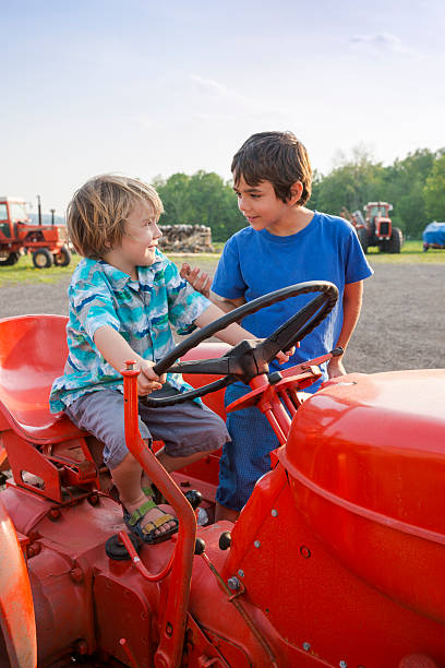 istock Two brothers on a farm tractor 180826115