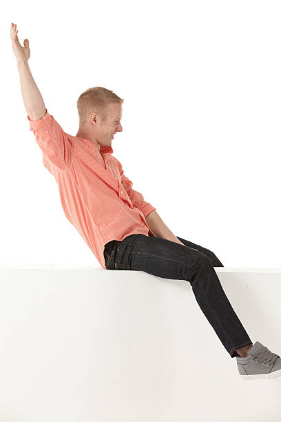 istock Happy man sitting on the ledge of wall 180826159