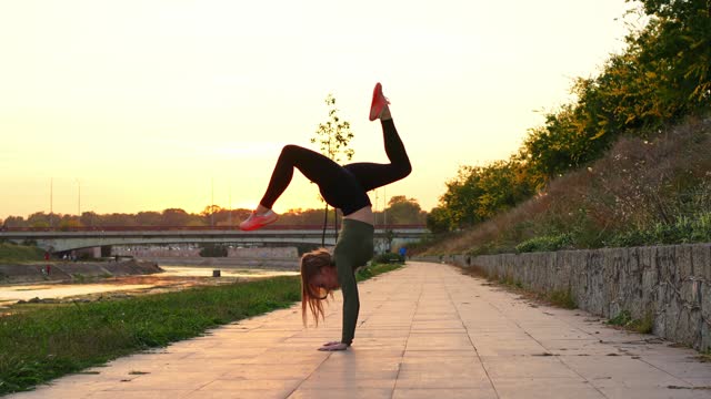 Sporty woman doing a handstand exercise