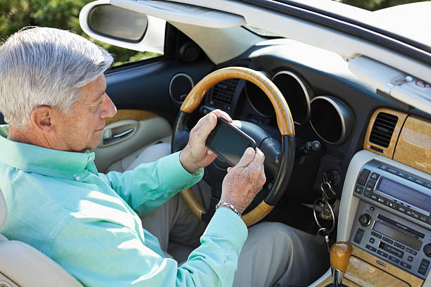 istock Senior man in convertible, texting 180826669