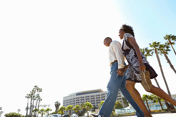 istock Stylish couple taking walk on California beach 180827042